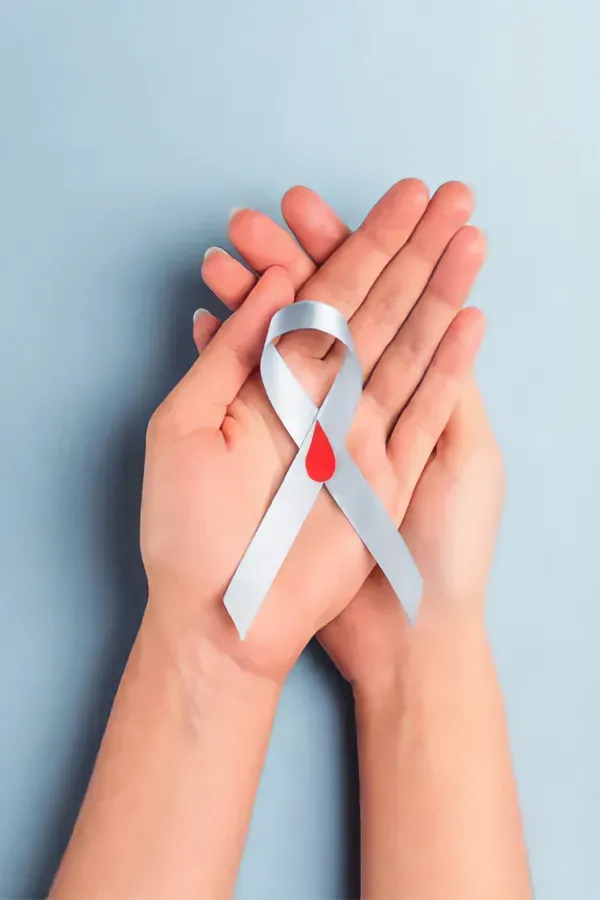 Diabetes-Treatment A woman's hands holding a white ribbon with a red drop symbol on it, symbolizing diabetes treatment from Delara Tavakoli, M.D. of Tavicare in Chevy Chase.