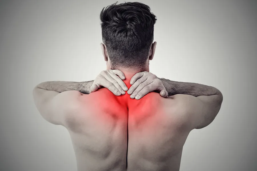 Fibromyalgia-Doctor An image from behind of a man suffering from Fibromyalgia rubbing an area illustrated red with pain in his shoulders and neck . Get fibromyalgia treatment from Delara Tavakoli, M.D. of Tavicare in Chevy Chase.