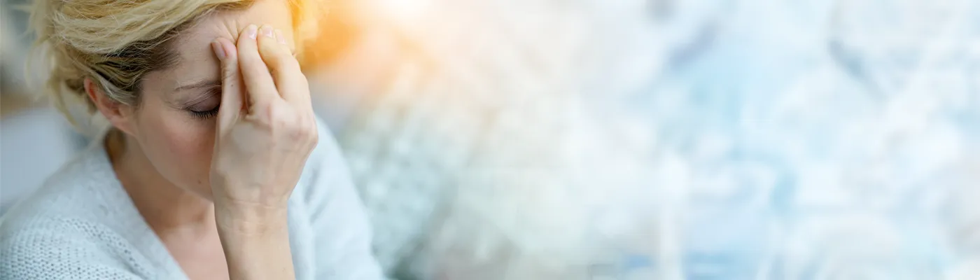 Migraine-IV-Therapy-Specialist A woman experiencing a migraine headache pinches her forehead. Get IV Therapy for migraine pain relief from Delara Tavakoli, M.D. of Tavicare in Chevy Chase.