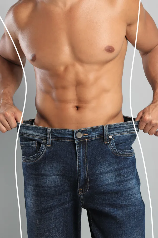 Semaglutide-Weight-Loss-Treatment A strong shirtless man in jeans holds the waistlines of his too-big jeans to show the success of semaglutide weight loss from Delara Tavakoli, M.D. of Tavicare in Chevy Chase.