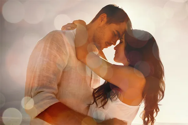 Sexual-Wellness-for-Women-and-Men-Doctor A couple in linen shirts standing in a sparkling light embraces each other with their foreheads touching and eyes closed, happy with their sexual wellness treatments from Delara Tavakoli, M.D. of Tavicare in Chevy Chase.