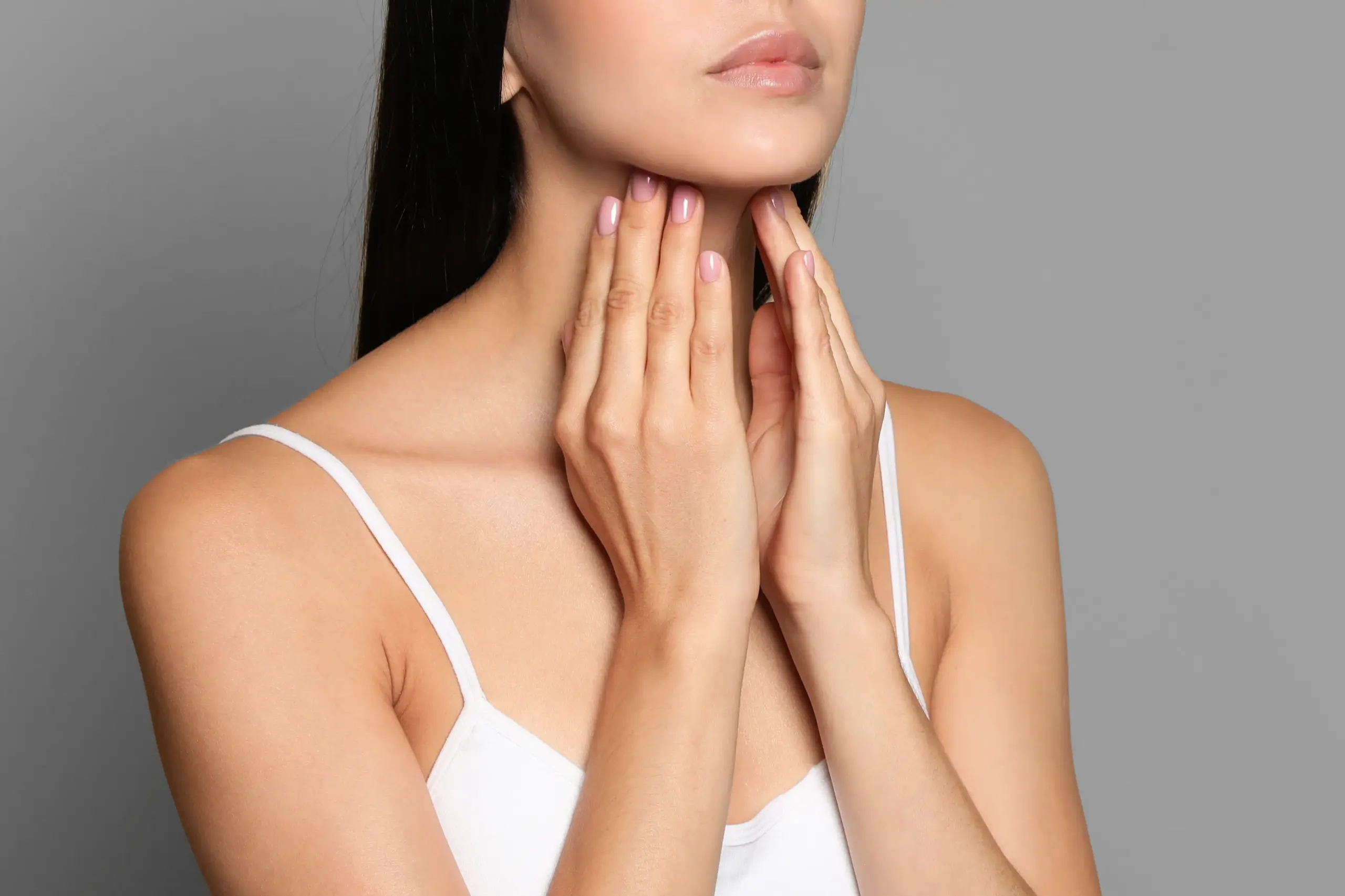 Thyroid-Doctor A woman in a white tank top touches her neck looking for signs of thyroid disorder. Get help for thyroid disorders from Delara Tavakoli, M.D. of Tavicare in Chevy Chase.